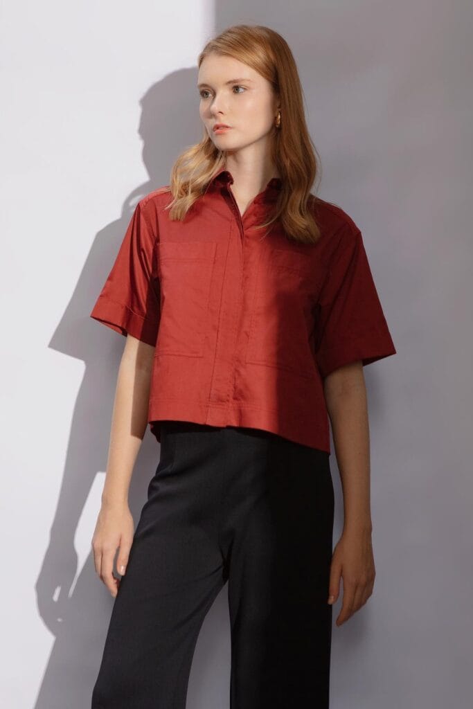 How To Style Oversized Shirts Like A Fashion Blogger 16 Woman Wearing A Red Oversized Shirt With Short Sleeves And Black Wide-Leg Pants, Standing Against A Neutral Background.
