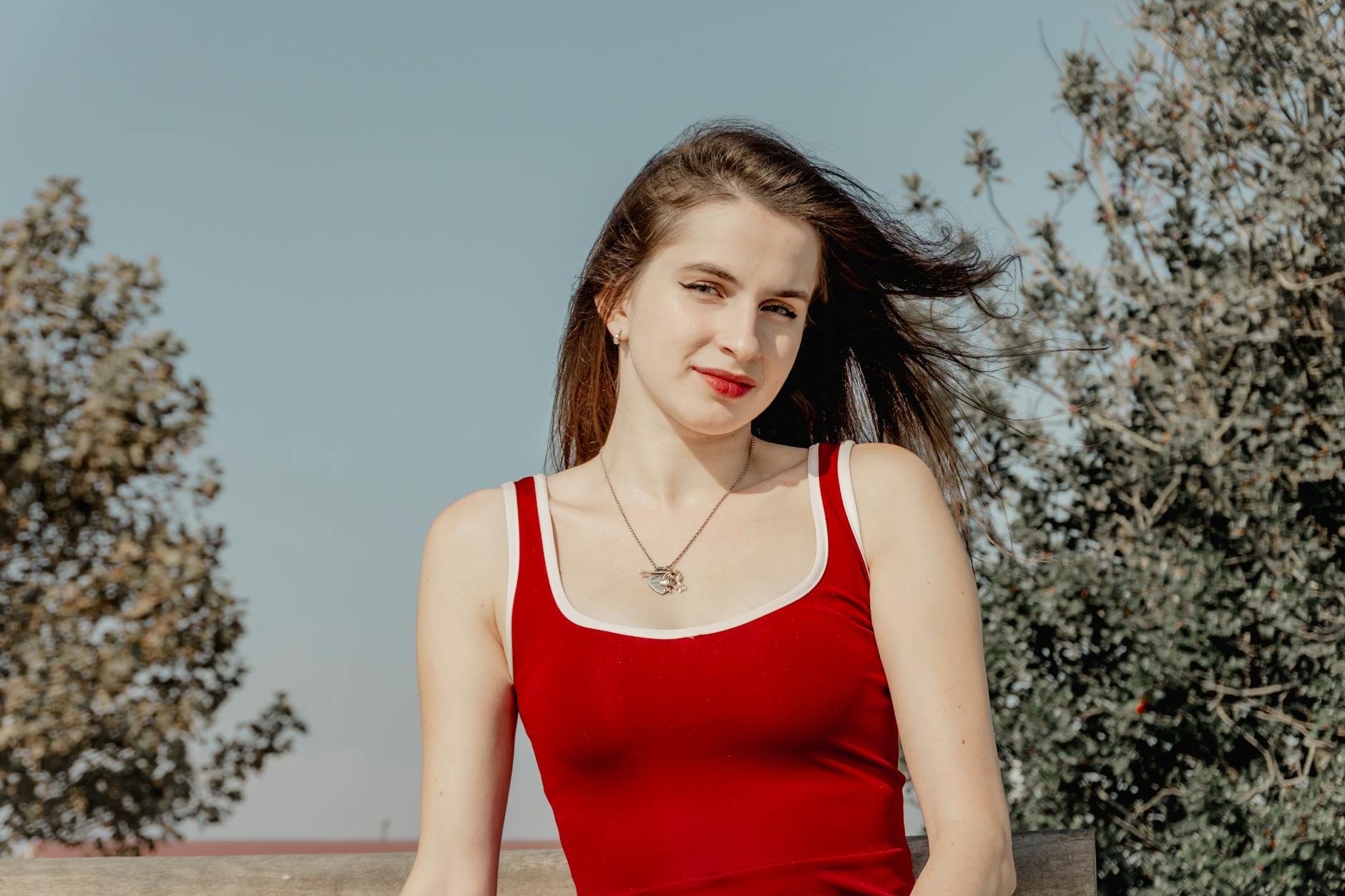 Confident Young Woman In Red Dress Outdoors